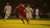 Spain soccer players in red jerseys attacking during an intense World Cup match on stadium pitch