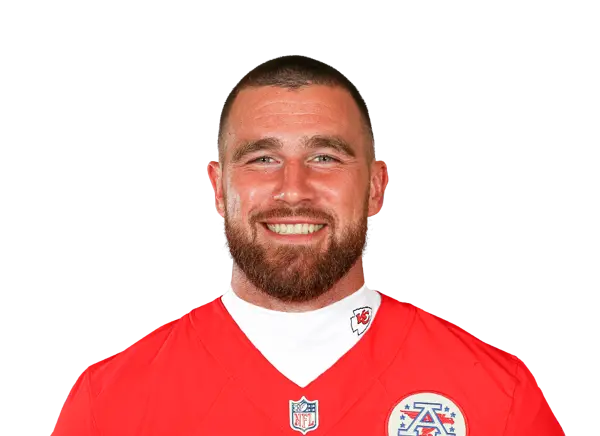 Travis Kelce smiling, wearing a Kansas City Chiefs jersey.