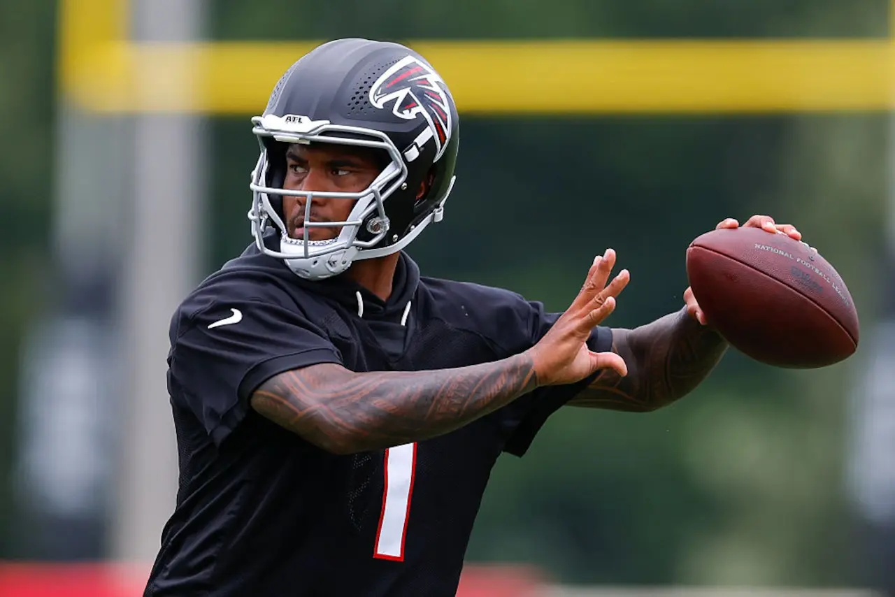 Atlanta Falcons player in a black jersey throwing a football during practice.