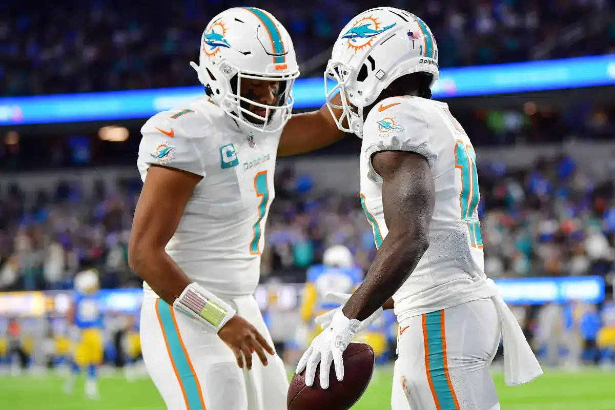 Tyreek Hill and Tua Tagovailoa celebrating during a Miami Dolphins game.