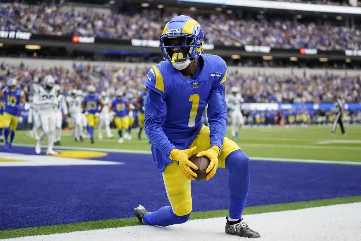 Los Angeles Rams wide receiver Allen Robinson kneeling on the field holding a football