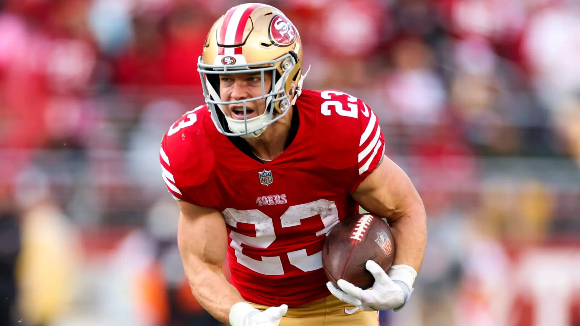 San Francisco 49ers running back Christian McCaffrey running with a football during a game.