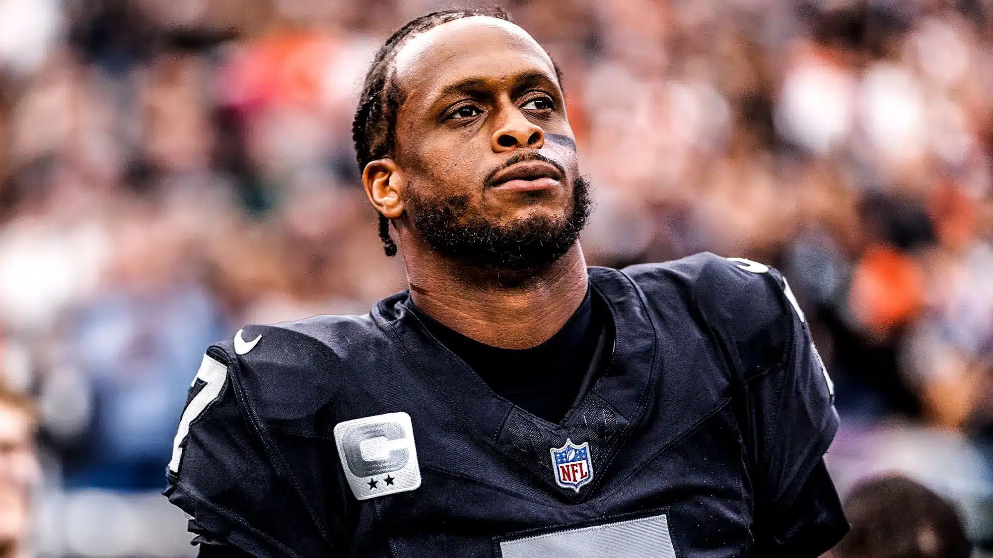 Geno Smith wearing a black New York Jets jersey with a captain's patch.