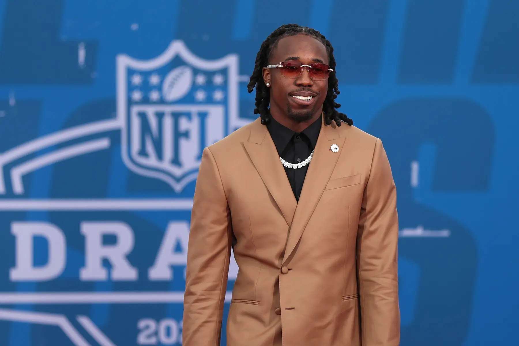 Joey Porter Jr. wearing a tan suit and sunglasses at the NFL Draft