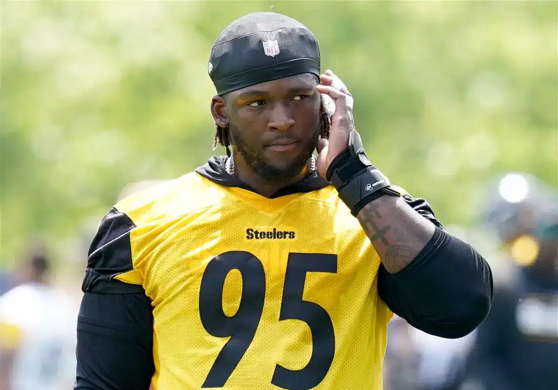 Keeanu Benton of the Pittsburgh Steelers wearing a yellow practice jersey with number 95