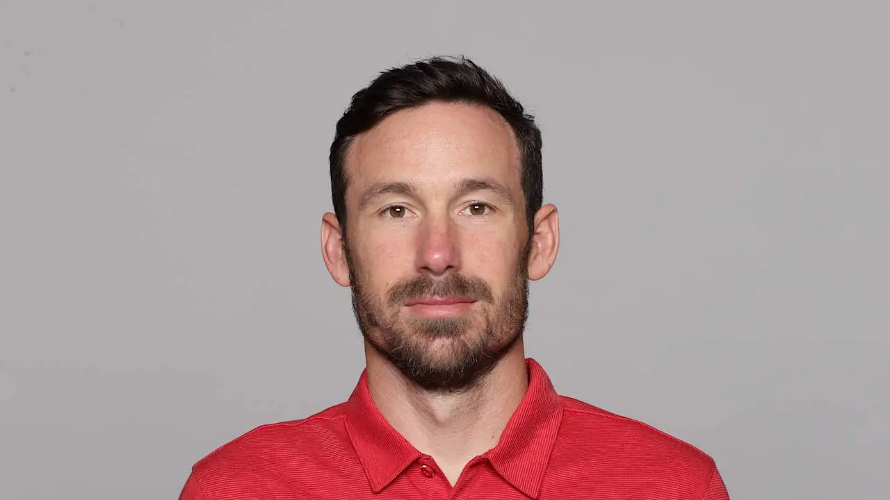 Headshot of Klint Kubiak wearing a red polo shirt against a gray background