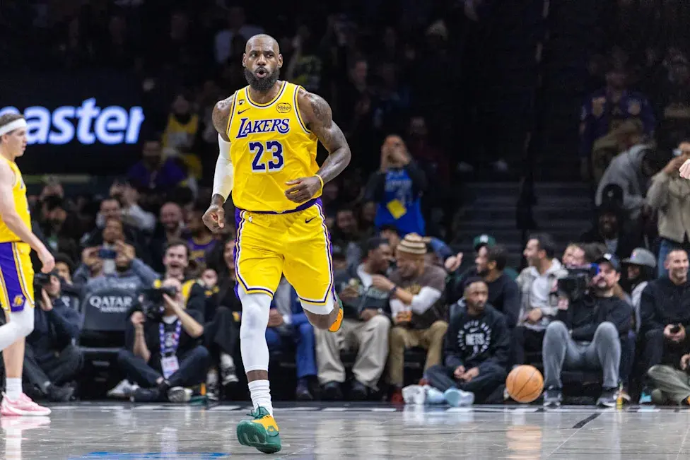 LeBron James wearing a yellow Los Angeles Lakers jersey running on an NBA basketball court during a game
