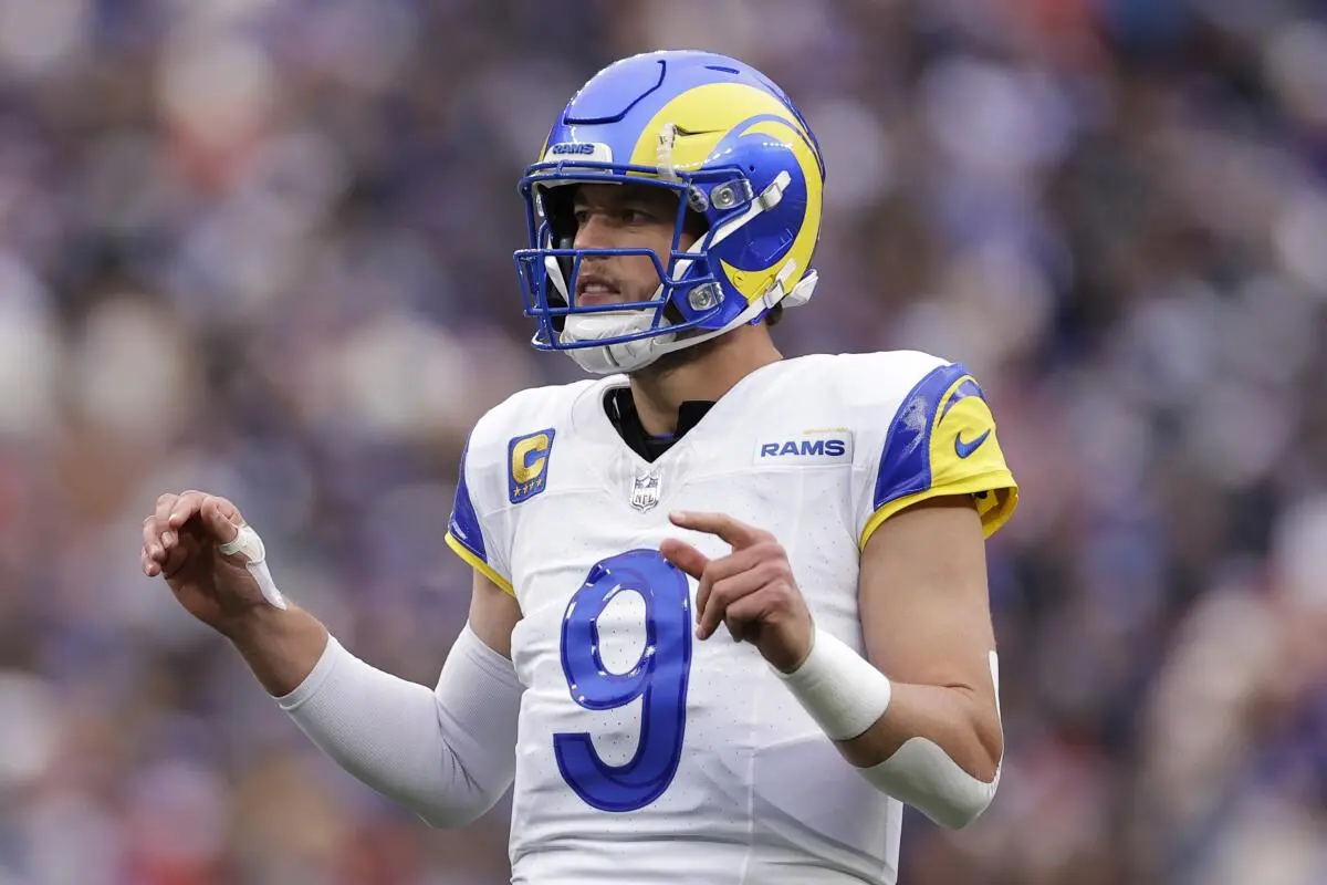Matthew Stafford of the LA Rams wearing a white jersey and blue helmet on the field