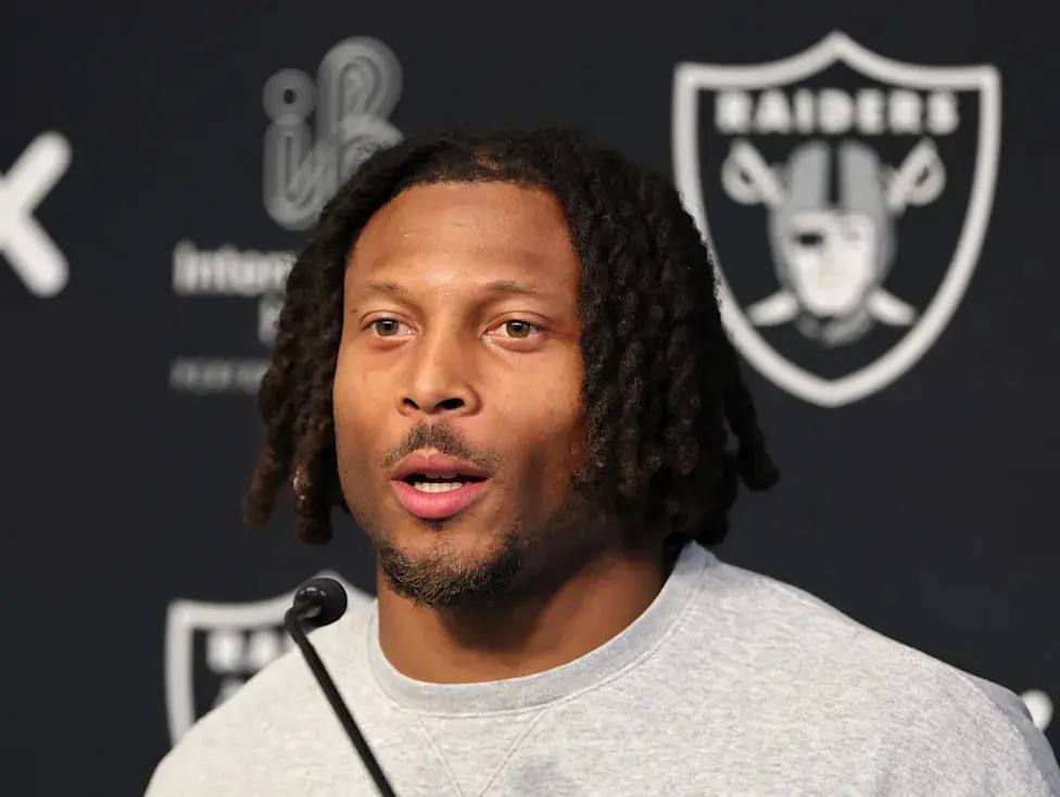 Close-up portrait of Tre Tucker speaking at a press conference with the Las Vegas Raiders logo in the background.