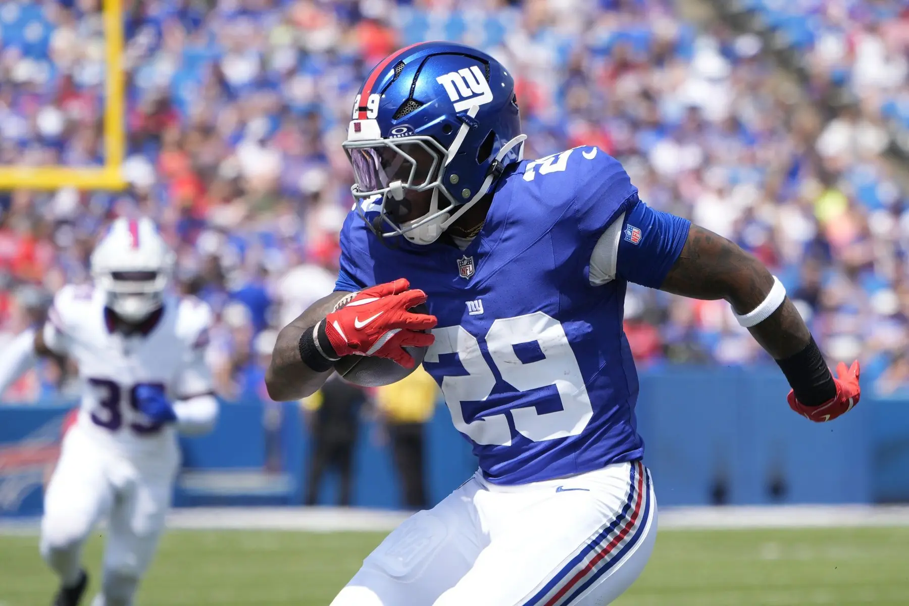 New York Giants football player wearing number 29 in a blue jersey running with the ball during a game.