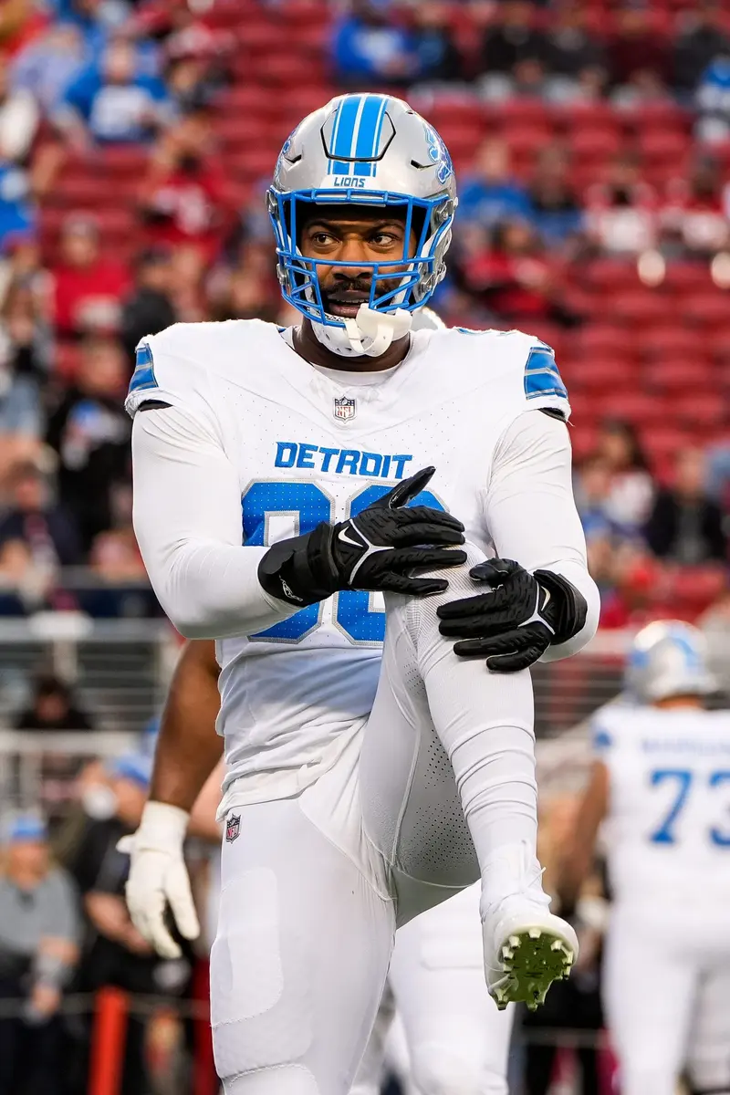 Za'Darius Smith wearing a white Detroit Lions jersey and helmet on the football field